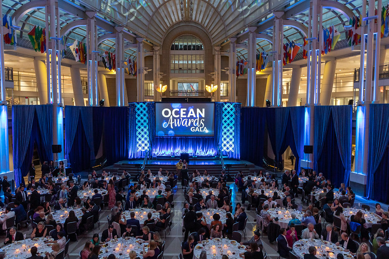 A photo of a Gala event from above showing many tables with seated people.